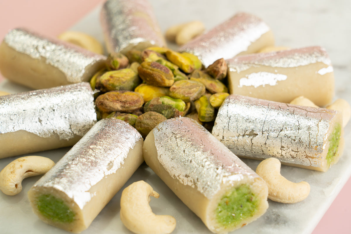 Close-up of fresh Kaju Pista Roll mithai, an authentic pure vegetarian dessert made with premium pistachios and zero preservatives.