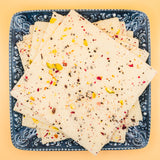 squares of authentic Vanilla Bombay Ice Halwa garnished with premium nuts, an artisanal Indian mithai by Pavitre.