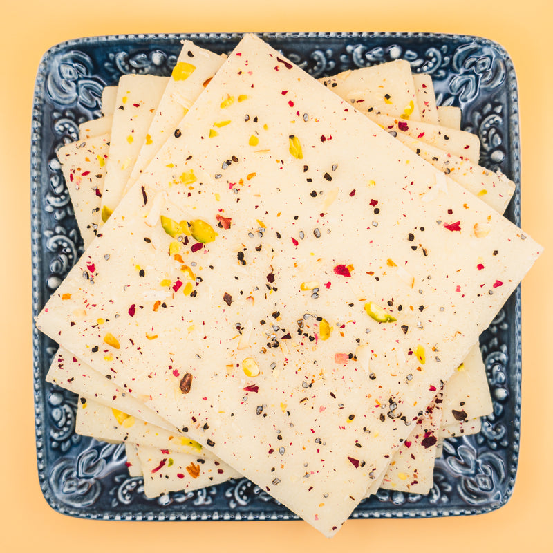 squares of authentic Vanilla Bombay Ice Halwa garnished with premium nuts, an artisanal Indian mithai by Pavitre.